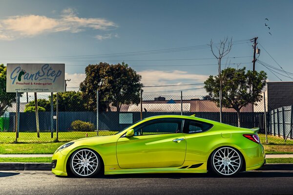 On the background of a green lawn of a similar color car