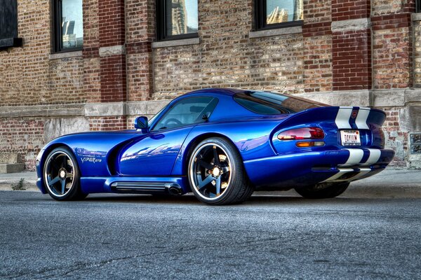 Un llamativo Dodge Viper GTS 04 azul contra una pared de ladrillo