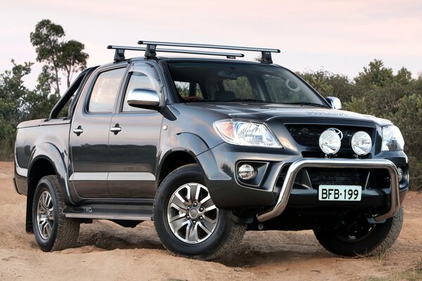 Camioneta toyota hilux negra en la arena