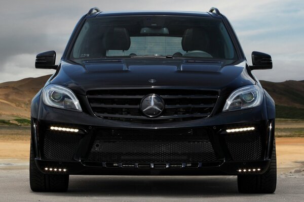 Sur la photo, une Mercedes noire roule sur la route