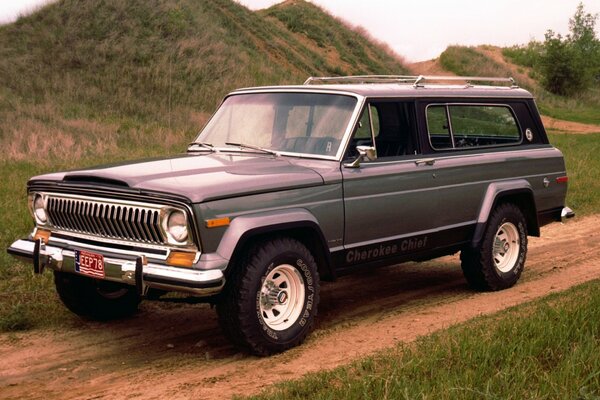 Jeep Cherokee 1976 vor dem Hintergrund der Hügel