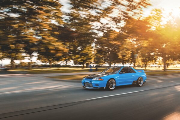 Coche azul bajo el sol en la pista