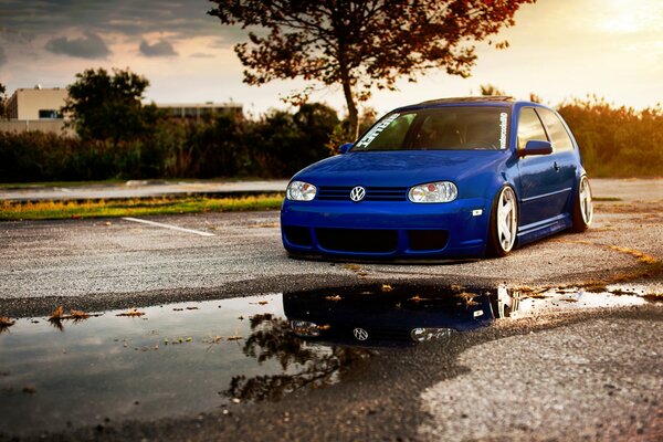 Blue Volkswagen Golf on the background of a beautiful sunset