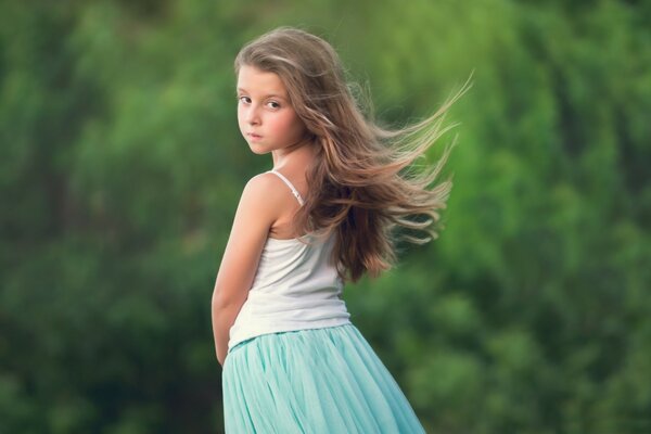 A beautiful girl in a dress looks back with sadness