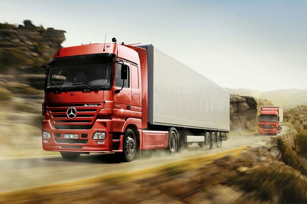 Trucks with Mercedes tractors are rushing along the road at high speed