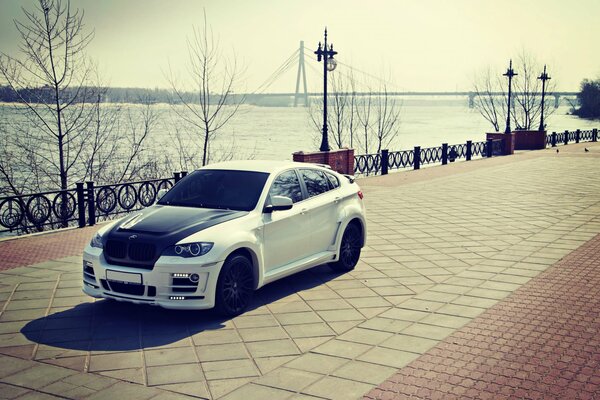 White car on the square on the background of the sea