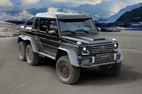 Mercedes steht vor dem Hintergrund der Berge auf dem Asphalt