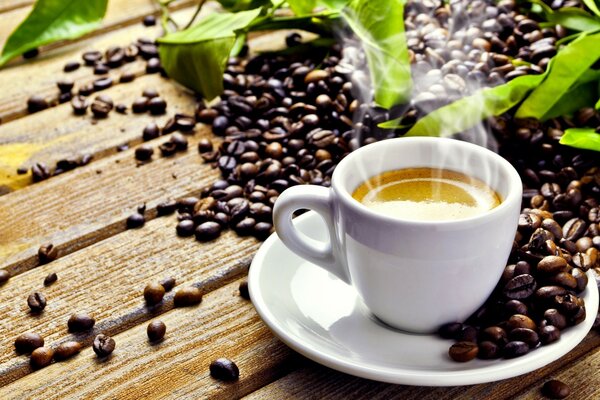 A mug of coffee on a plate next to the coffee beans