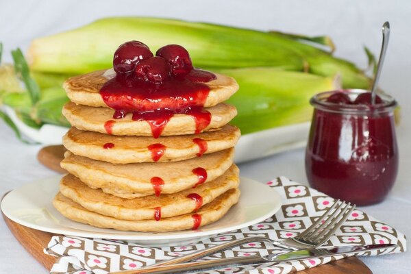 Pfannkuchen mit Kirschmarmelade auf einem Teller übergossen