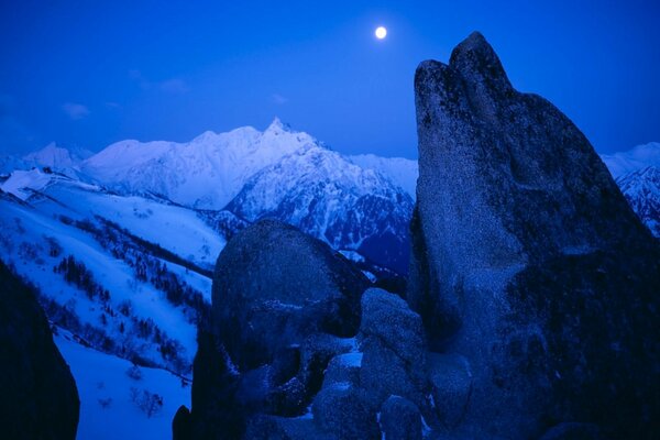 Montagnes enneigées et la lune dans le ciel