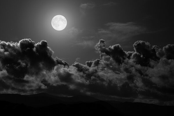 Luna llena en el cielo negro con nubes