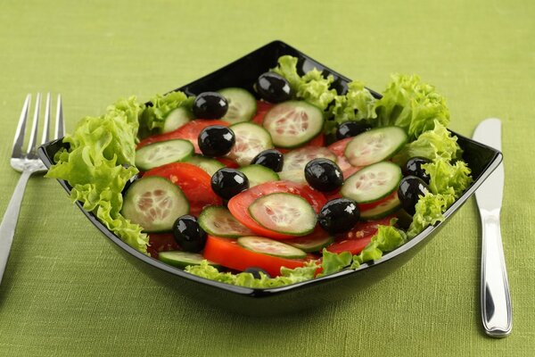 Salad with tomatoes, olives and cucumbers on a beautiful plate