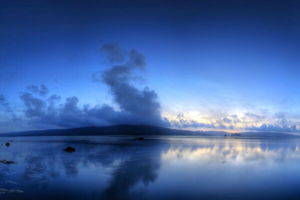 Il lago mostra magnificamente le colline blu