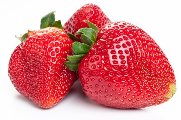 Trois fraises rouges sur fond blanc