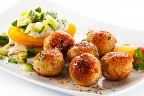 Albóndigas con verduras al horno en un plato blanco