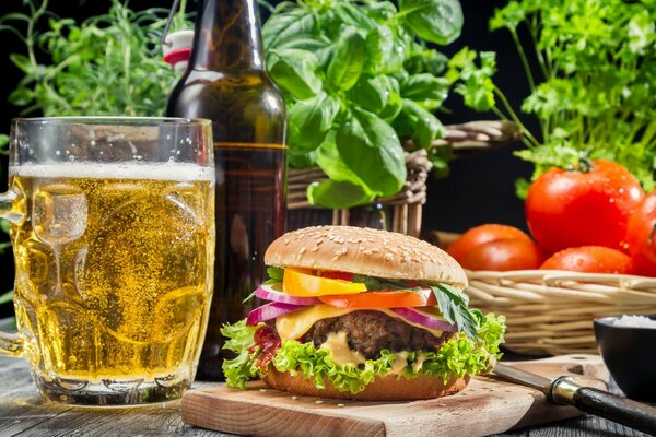 Hamburguesa jugosa con una taza de cerveza