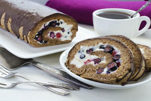 Rotolo di cioccolato con bacche e tazza di tè