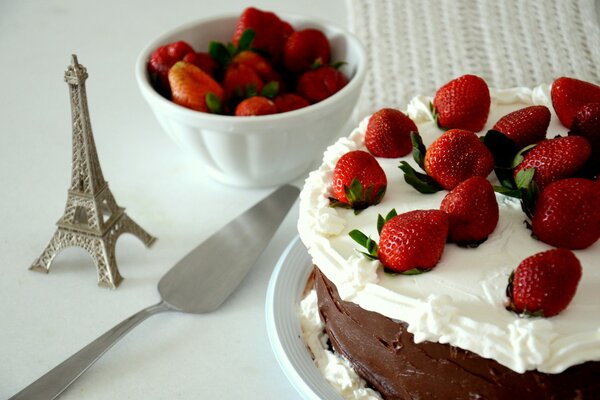 Strawberry cake and a tower figurine on a light background