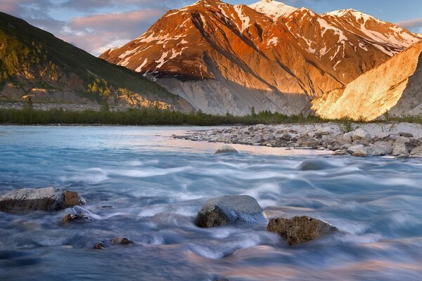 A turbulent current. Mountains in the sunlight