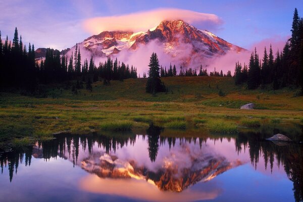 Riflessione nel lago di grande montagna con le nuvole