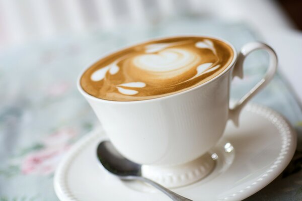 A cup of coffee with a pattern on the foam