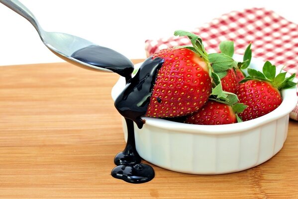 Fragole in una tazza versate con cioccolato