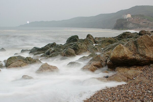 Waves cover the shore with rocks