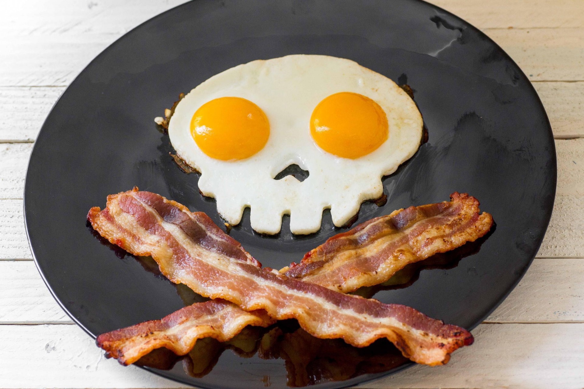 eyes skull scrambled eggs skeleton black plate yolk eggs bacon