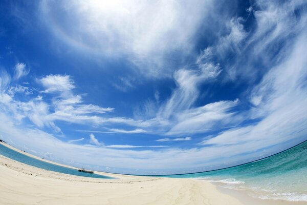 Scattered clouds cover water, sand