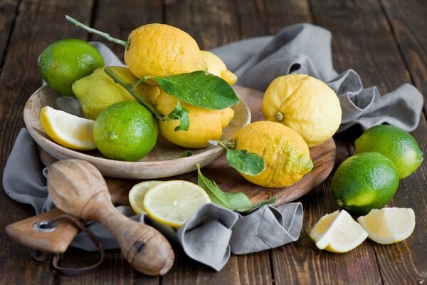 A bowl with lemon and lime on the board