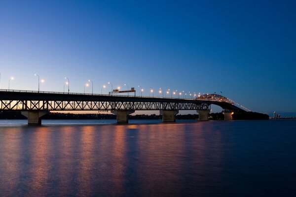 Pont avec des lumières du soir menant à la ville