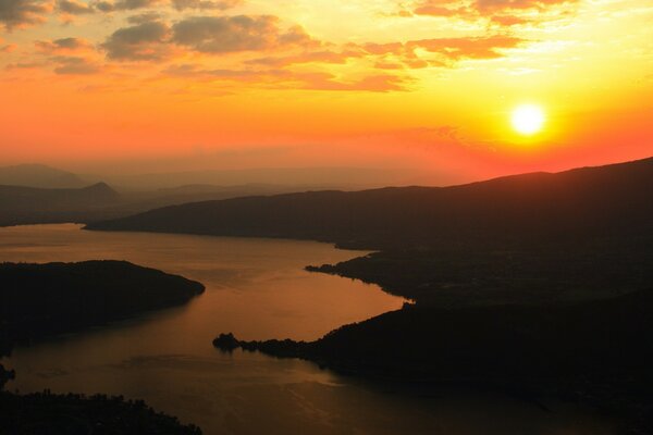 Fluss in den Strahlen der untergehenden Sonne Wolken am Sonnenuntergang Hintergrund