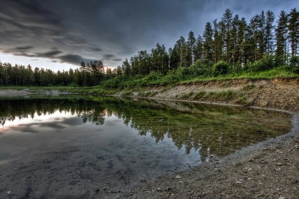 Los árboles y las nubes se reflejan en el agua