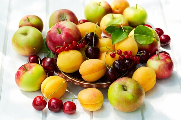 Apples, apricots, cherries in a plate