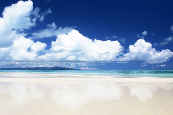 Big white clouds and a white beach