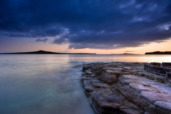 Vista de la bahía de la tarde desde la costa rocosa