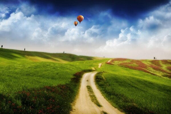 A field with a dirt road and balloons