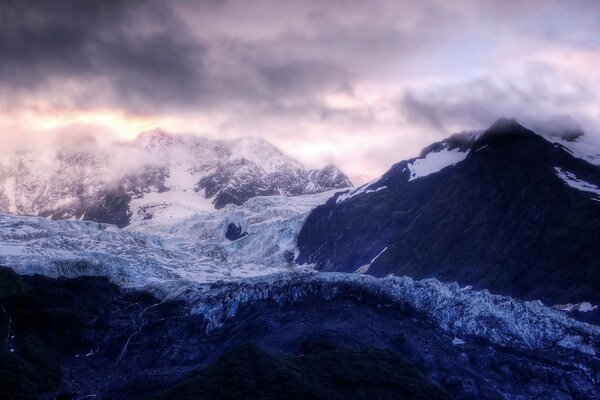 Sommets des montagnes gelées dans les nuages