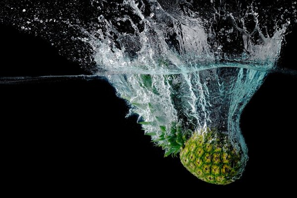 Piña cayó al agua sobre un fondo oscuro