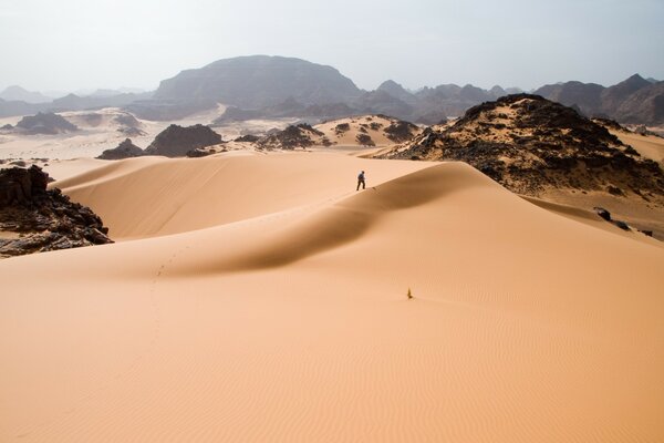 Ein Mann in der Wüste geht durch den Sand