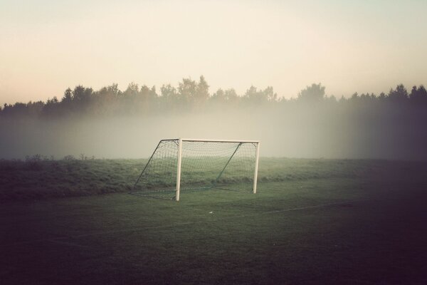 Campo di calcio smussato, campo di calcio al mattino, cancello di calcio nella nebbia