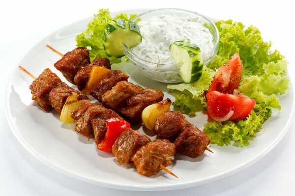 Barbecue on skewers with vegetables and sauce