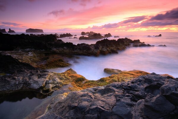 Sunset over misty mountains by the sea