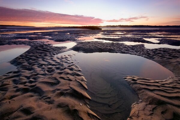 L aube se reflète dans les flaques d eau sur le rivage sablonneux