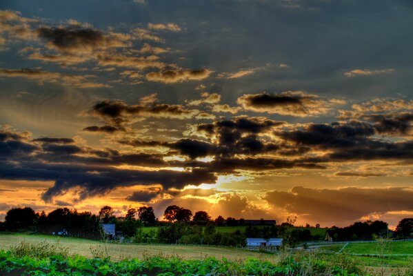 Beautiful clouds over the village and the green field