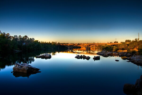 Pont sur la rivière bleue au coucher du soleil