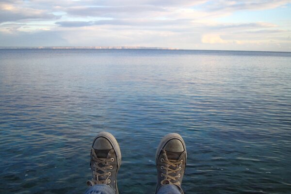 Turnschuhe auf dem Hintergrund eines schönen Morgensees