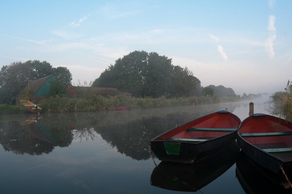 2 barche in mezzo al fiume nella nebbia