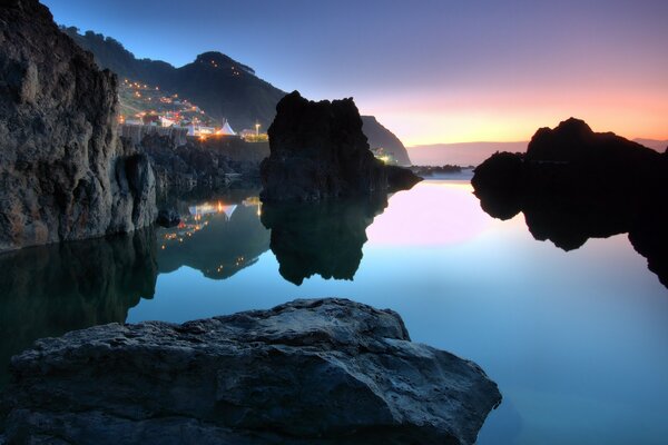 A bright city against the background of rocks, the sea and a warm evening