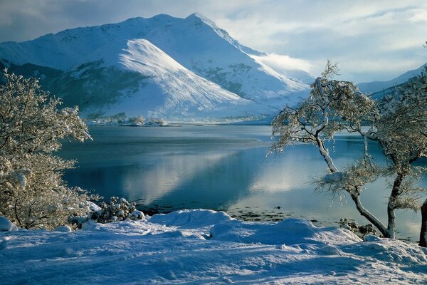 Winteransicht des Flusses vor dem Hintergrund der Berge